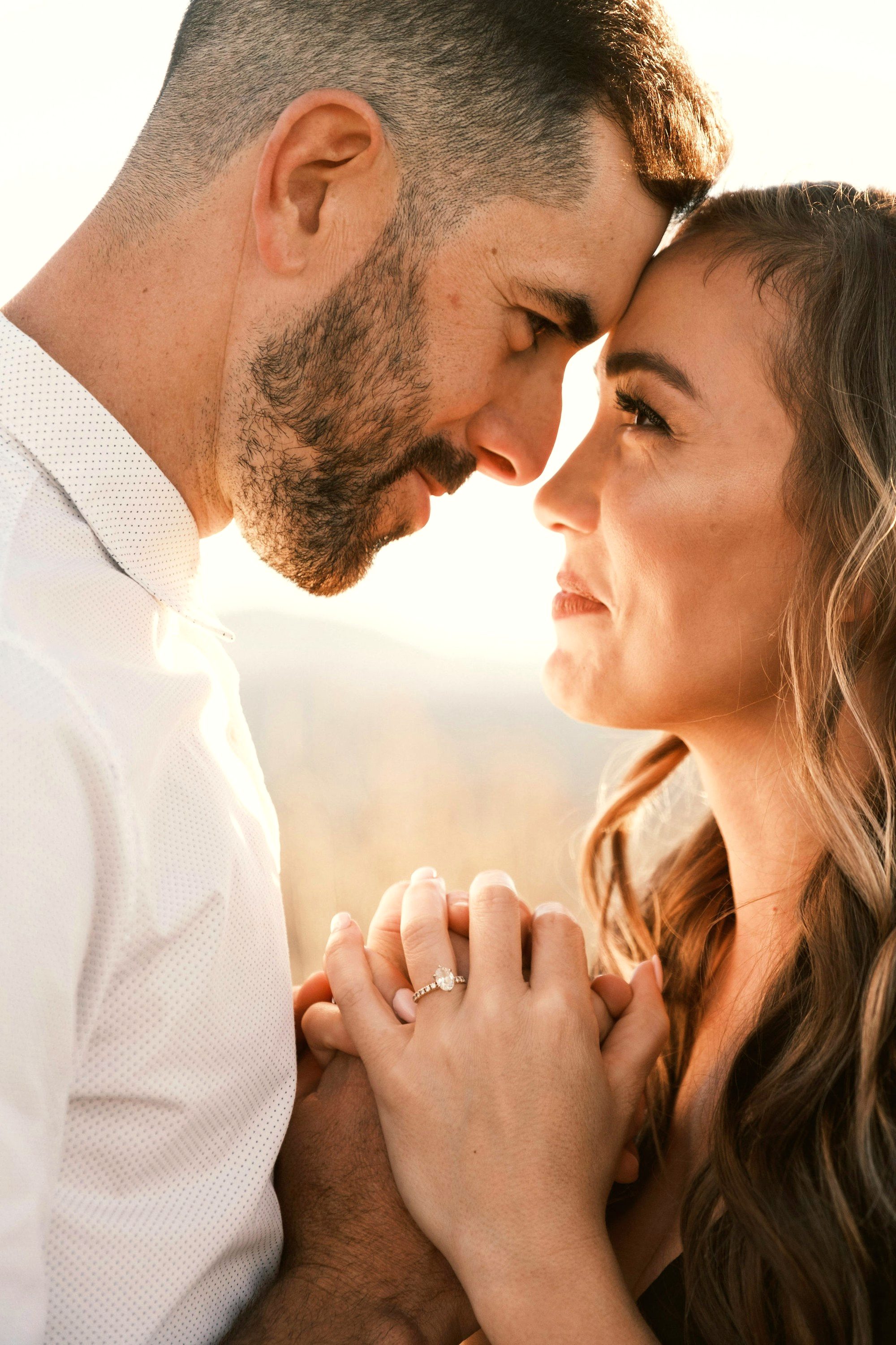 A couple sharing a quiet, intimate moment in golden-hour light