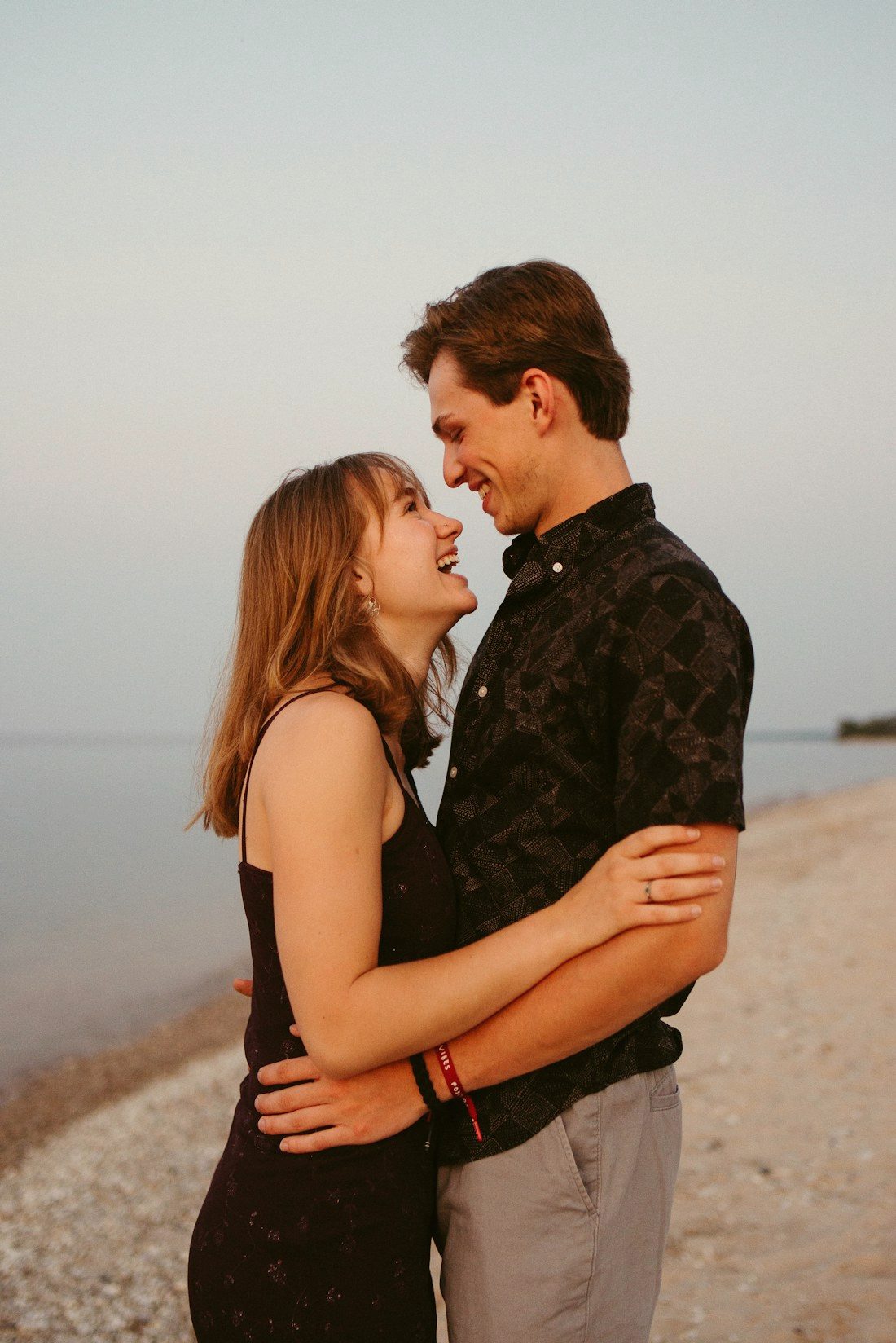 An engaged couple close together at golden hour