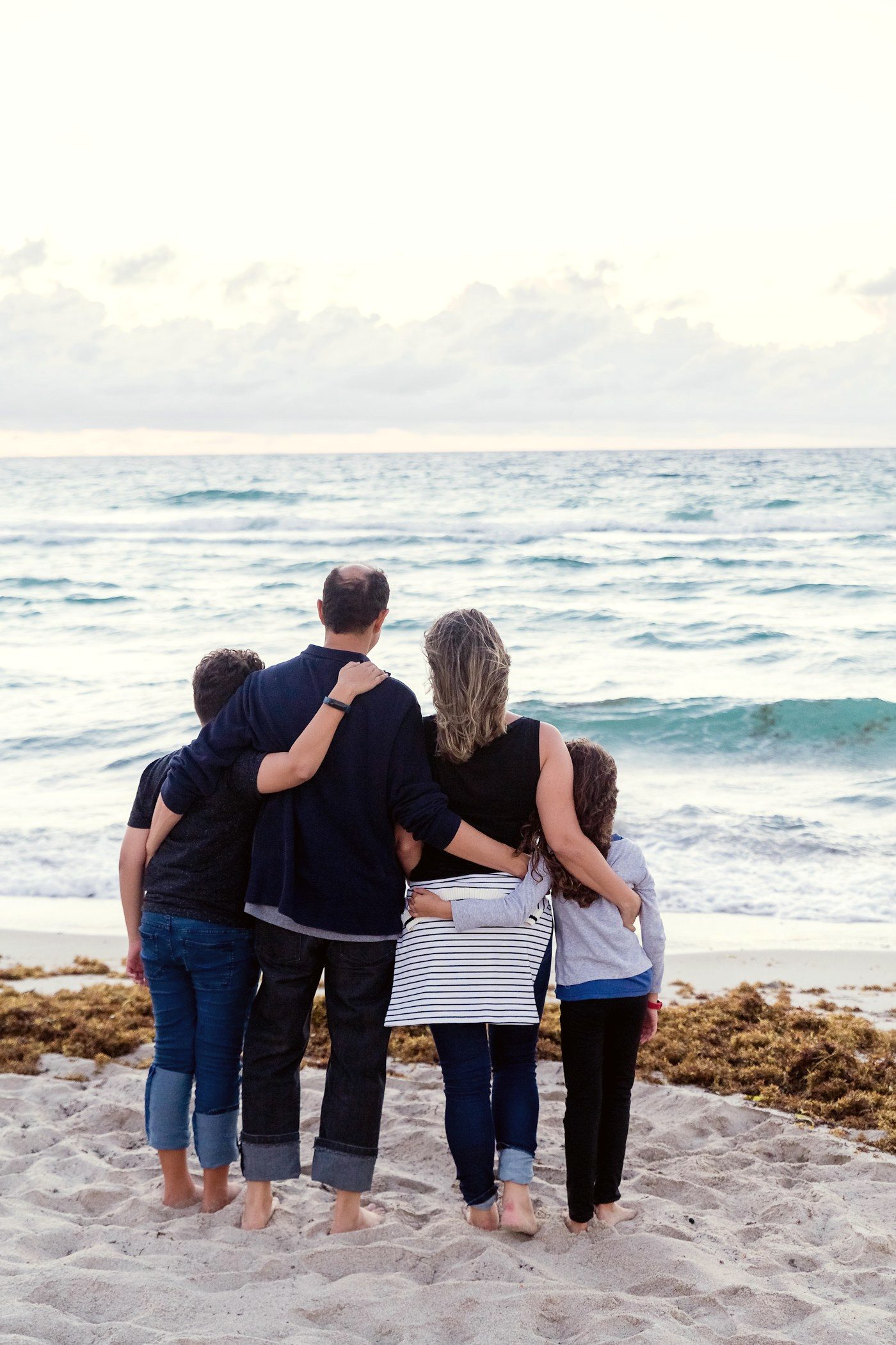A family laughing together outdoors in warm light